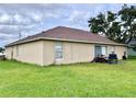 Rear view of a one-story house with patio and backyard at 324 Baccarat Ct, Kissimmee, FL 34759