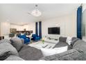 Open living area with sectional sofa, large TV, and stylish decor at 1676 Moon Valley Dr, Davenport, FL 33896