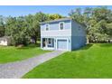 Newly built two-story home with light blue exterior and a gravel driveway at 1024 Carlisle St, Haines City, FL 33844