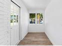 Bright sunroom with white brick walls, wood-look flooring, and large windows at 751 Avenue B Sw, Winter Haven, FL 33880