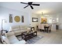 Open living and dining area with beige couch and dining table at 4734 Vero Beach Pl, Kissimmee, FL 34746