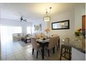 Dining room with beige chairs and a view into the living room at 4734 Vero Beach Pl, Kissimmee, FL 34746
