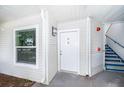 Exterior entryway with white door and blue stairs at 2532 Woodgate Blvd # 105, Orlando, FL 32822