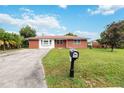 Brick home with a large yard, driveway, and mailbox at 7819 Puritan Rd, Orlando, FL 32807