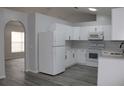 Bright kitchen with white cabinets, stainless steel appliances, and vinyl flooring at 411 Gannet Ct, Kissimmee, FL 34759