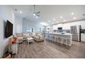 Open-concept kitchen with island, stainless steel appliances, and white cabinets at 872 Sydney St, Davenport, FL 33837