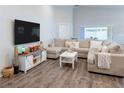 Large living room with L-shaped sectional sofa and wood-look floors at 872 Sydney St, Davenport, FL 33837
