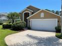 Tan two-story house with a white garage door and landscaping at 1652 Dunes Ct, Haines City, FL 33844