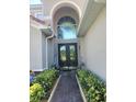 Elegant entryway with double doors and landscaping at 1711 Windward Oaks Ct, Kissimmee, FL 34746