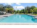 Community pool with lounge chairs and surrounding landscaping at 4523 Cypress Cay Way, Kissimmee, FL 34746