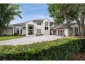 Luxury home with a paved driveway and lush landscaping at 5126 Fairway Oaks Dr, Windermere, FL 34786