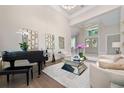 Elegant living room with a grand piano, comfortable seating and large windows at 5126 Fairway Oaks Dr, Windermere, FL 34786