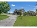 Two-story home with a circular driveway, landscaping and detached garage at 3105 Pastures Rd, Kissimmee, FL 34746