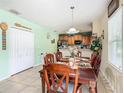 Bright dining area with a wooden table and view into kitchen at 1880 Monte Cristo Ln, Kissimmee, FL 34758