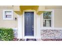 Dark gray front door with a stone and light yellow exterior at 14315 Swanley St, Orlando, FL 32832