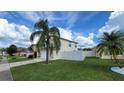 Two-story house with a white fence and palm trees in the front yard at 3011 Bransbury Ct, Kissimmee, FL 34747
