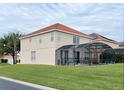 Two story house with tan exterior, tile roof and screened pool at 256 Sevilla Ave, Davenport, FL 33897