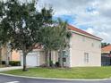 Two story house with tan exterior, tile roof and a two car garage at 256 Sevilla Ave, Davenport, FL 33897