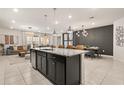 Modern kitchen with dark cabinetry, granite countertops, and a large island at 3525 Lavender Dr, Davenport, FL 33897