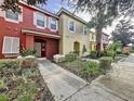 Row of townhomes with red and yellow exteriors at 8472 Crystal Cove Loop, Kissimmee, FL 34747