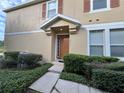 Tan two-story house with a brown door, two-car garage, and neatly landscaped front yard at 10791 Gran Paradiso Dr # S, Orlando, FL 32832