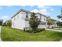 Two-story home with white exterior, landscaping, and a view of the side yard at 9099 Hazard St, Davenport, FL 33896
