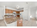 Spacious kitchen with light wood cabinets, granite countertops, and stainless steel appliances at 1746 Pompano Dr, Poinciana, FL 34759