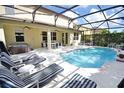 Inviting pool and spa area with lounge chairs under a screened enclosure at 133 Alfani St, Davenport, FL 33896