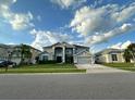 Two-story house with a gray exterior, landscaping, and a two-car garage at 2321 Hinsdale Dr, Kissimmee, FL 34741