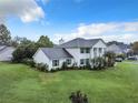 Two-story house, white siding, grey roof. Landscaped yard with spacious green lawn at 4155 Quail Wood Dr, St Cloud, FL 34772