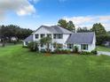 Two-story house with white siding, grey roof, and a large green lawn at 4155 Quail Wood Dr, St Cloud, FL 34772