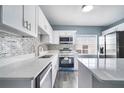 Modern kitchen featuring white cabinets, quartz countertops, and stainless steel appliances at 4810 Burgundy Ln, Orlando, FL 32808