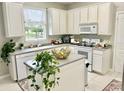 Kitchen with island, white cabinets, and granite countertops at 3040 Palermo Rose Way, Kissimmee, FL 34746