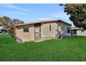 Tan mobile home exterior with a green lawn at 450 Tivoli Park Dr, Davenport, FL 33897