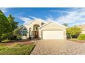 Tan house with a two-car garage and a red door at 223 Lake Davenport Estates, Davenport, FL 33897