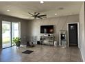 Open living room featuring tile floors and a large TV at 12254 Sandy Apple Rd, Orlando, FL 32824