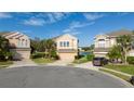 Three-story houses in a cul-de-sac neighborhood with palm trees and a lake view at 1542 Sun Meadow Dr, Orlando, FL 32824