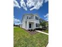 Two-story house with gray siding, blue door, and landscaped yard at 2893 Fitness St, Clermont, FL 34714