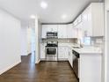 Modern kitchen with white cabinets and stainless steel appliances at 117 W Maple St, Davenport, FL 33837