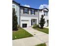 Two-story townhome with gray and white siding, two-car garage, and landscaping at 114 Mandovi St, Davenport, FL 33837