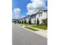 Row of townhouses with light-colored siding and landscaping at 114 Mandovi St, Davenport, FL 33837