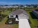 Single-Gathering home with a gray roof and landscaped yard at 4743 Magnetite Loop, Mount Dora, FL 32757