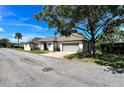 Side view of a single-story house with a gray garage door and a tree providing shade at 1493 Magellan Cir # 504, Orlando, FL 32818