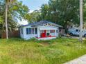 1920s bungalow with red door and overgrown yard at 1015 Ohio Ave, Saint Cloud, FL 34769