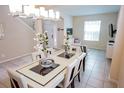 Bright dining room with a glass-top table and modern chandelier at 2505 Dharma Cir, Kissimmee, FL 34746