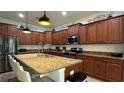 Spacious kitchen with island, dark wood cabinets, and granite counters at 8860 Candy Palm Rd, Kissimmee, FL 34747