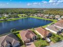 Aerial view of a lakefront home community, showcasing houses with tile roofs and lush landscaping at 678 Irvine Ranch Rd, Kissimmee, FL 34759