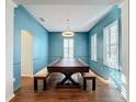 Elegant dining room features a large wood table, blue walls, and plantation shutters at 307 Norfolk St, Celebration, FL 34747