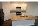 Modern kitchen features island with double sink, white cabinets, and stainless steel appliances at 1823 Veterans Dr, Kissimmee, FL 34744