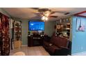 Living room with brown leather sofa and large TV at 2440 Summerfield Way, Kissimmee, FL 34741